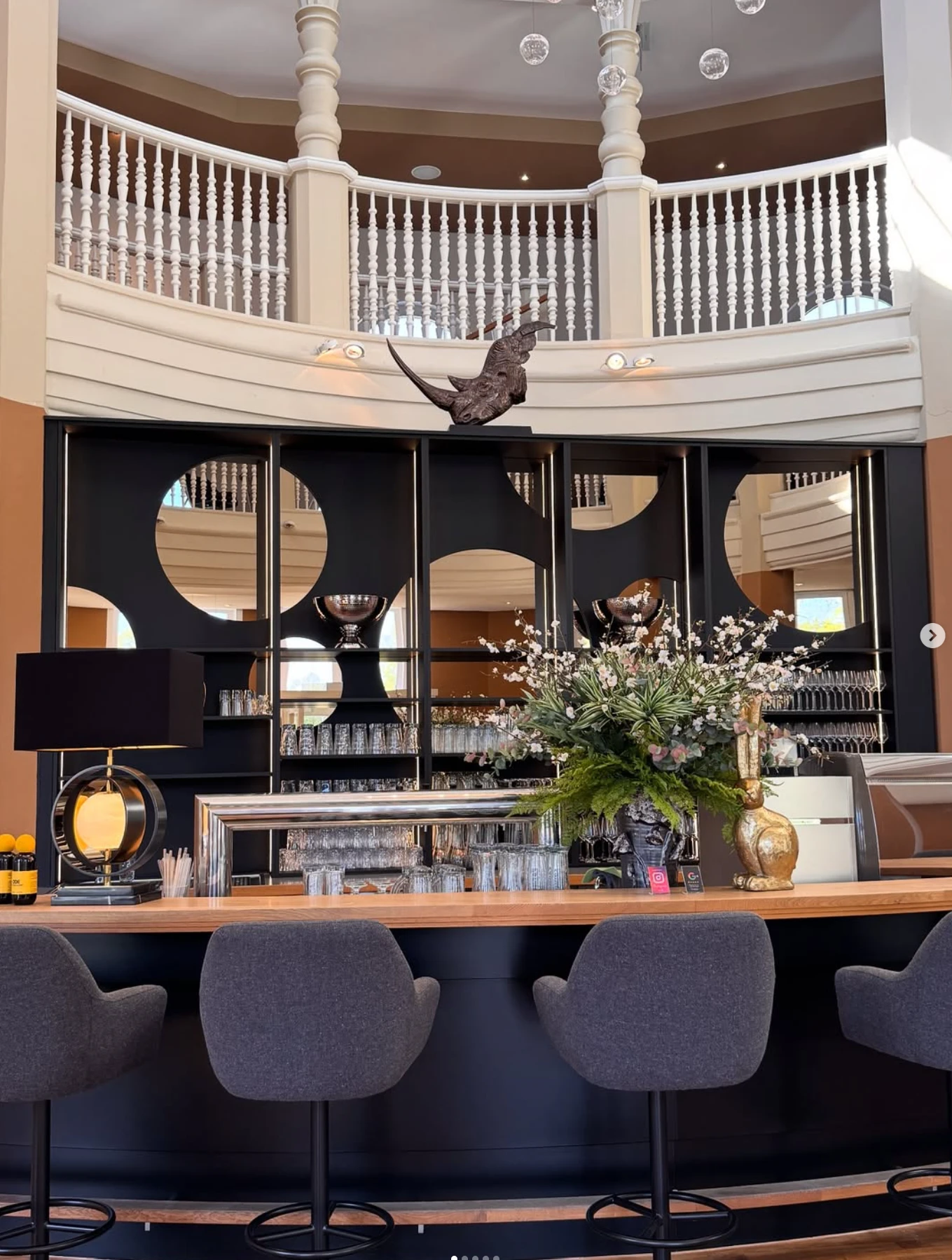 Geschwungene Bartheke mit Massivholzauflage in einem Hotelfoyer